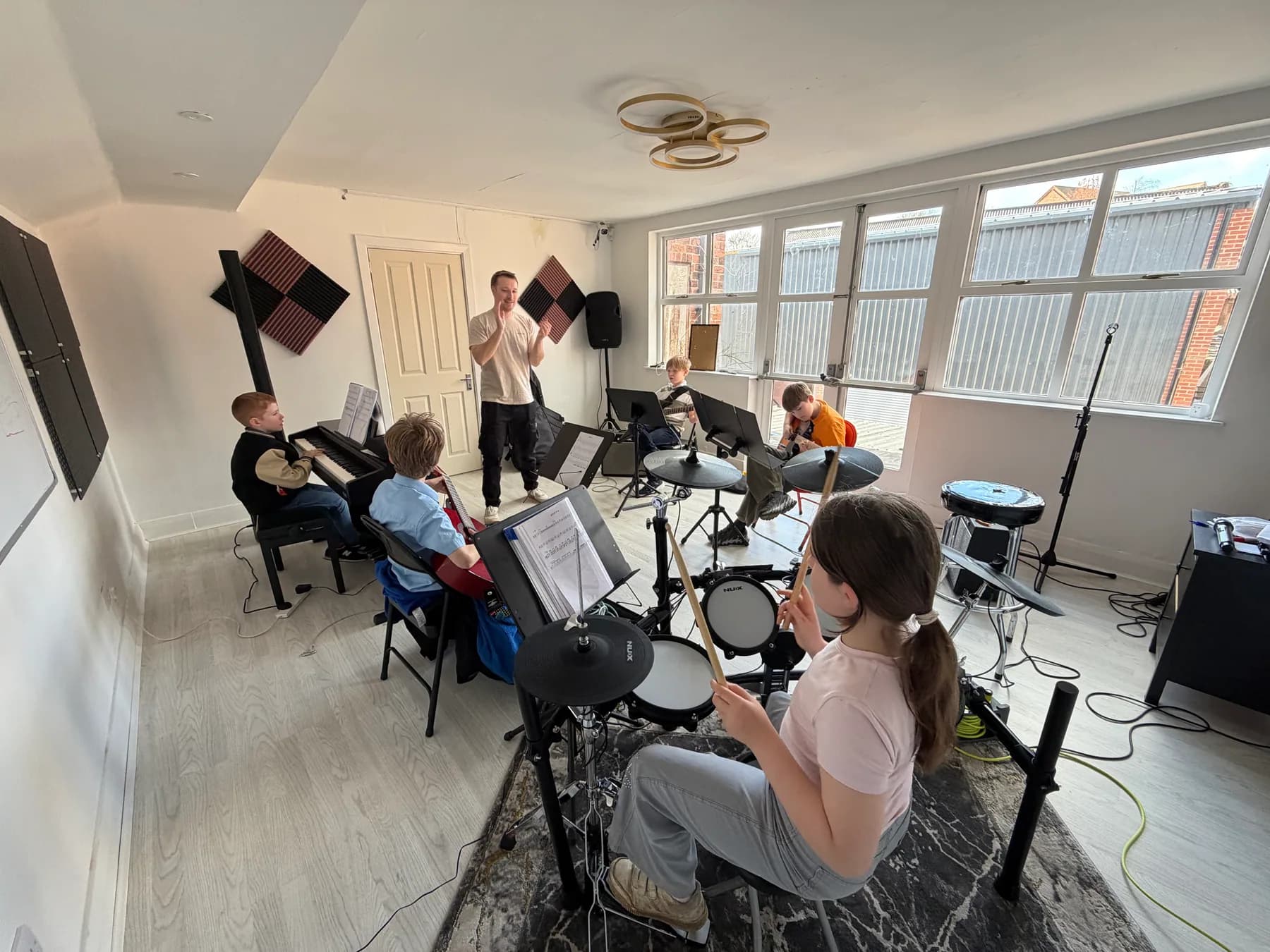 Apollo students rehearsing together with their teacher